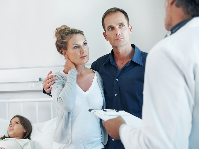 Eltern im Gespräch mit einem Arzt über ihre Tochter im Krankenhaus