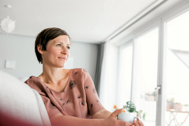 Eine Frau hält eine Tasse in der Hand.